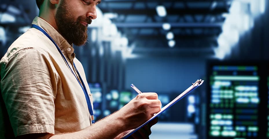Technicien utilisant une tablette devant des serveurs
