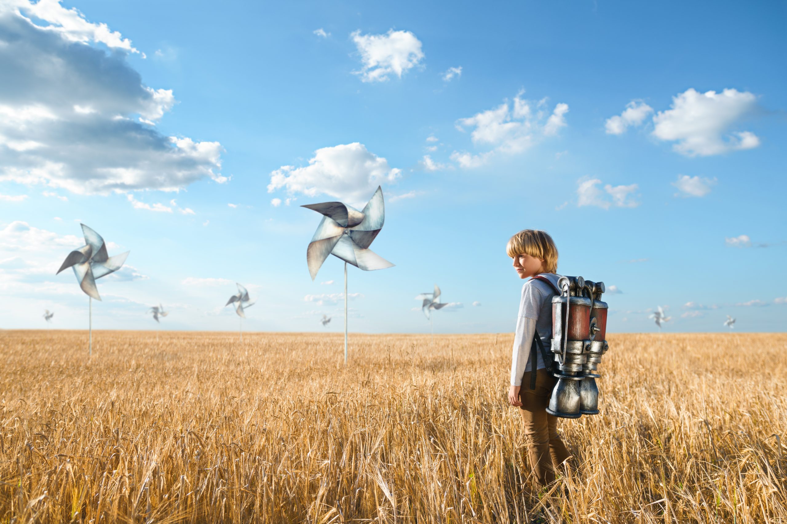 Un homme avec un sac à dos dans un champ avec des éoliennes. C'est une image d'illustration principale utilisé sur le site de l'agence digitale AXELITES